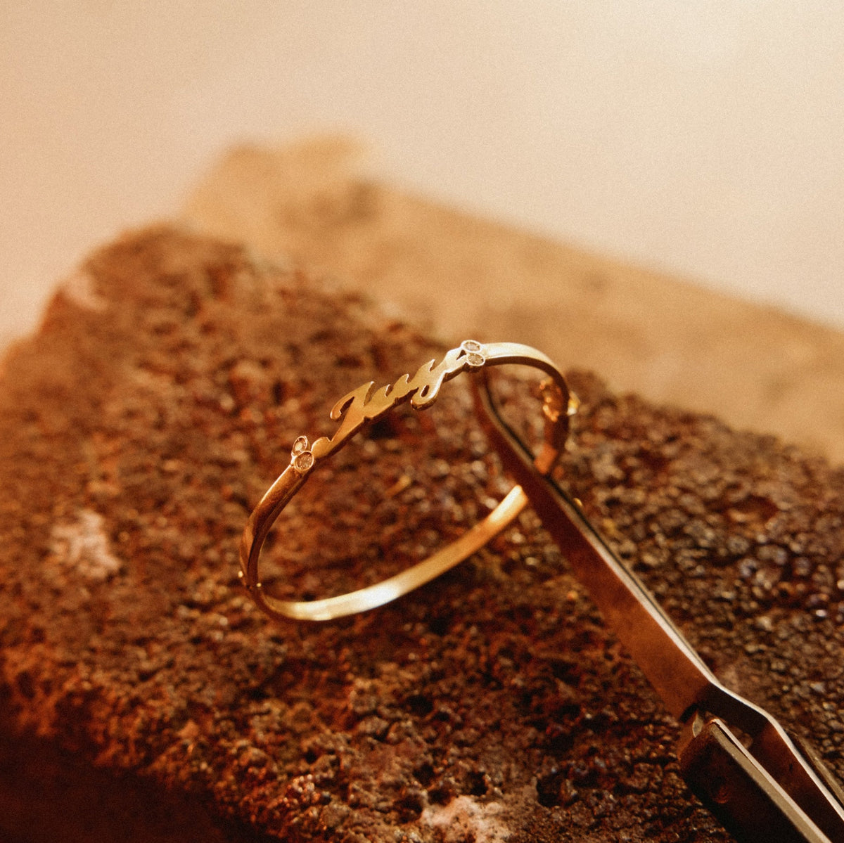 Fine 18k gold name bracelet with a single name in script and bezel-set diamonds at either end